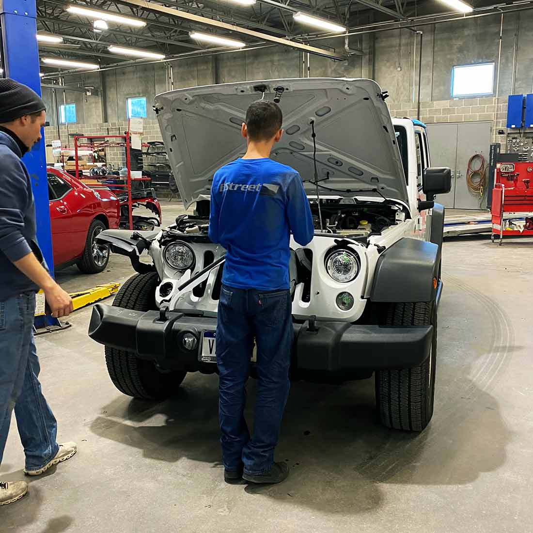 B Street collision repair technician working on a vehicle